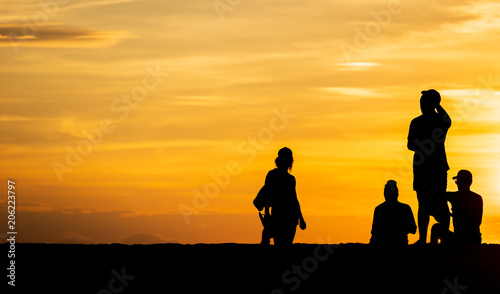 Groups of silhouette people Do activity on the beach on the Sunset and show the posture during a vacation at the tropical beach in travel and holiday concept.