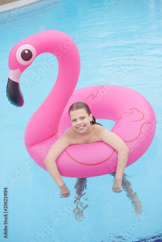 girl in pool in pink flamingo © klavdiyav