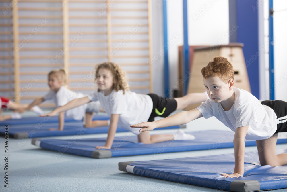 Fototapeta premium Kids exercising balancing yoga pose