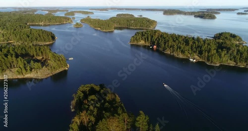 Boat in the archipelago, C4k aerial view following a boat driving between finnish islands, outside skaldo, on a sunny summer sunset evening dawn, in Baggo, Uusimaa , on the gulf of Finland