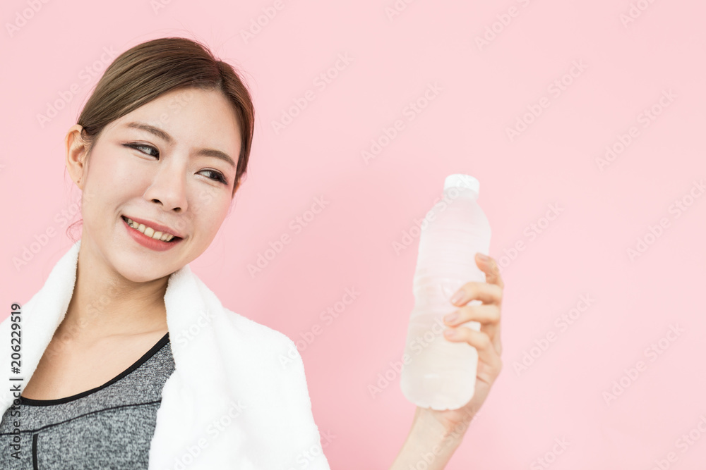 Beautiful Attractive Sporty Asian woman wearing fitness wear and holding fresh water feeling so fresh and healthy isolated on pink background Beautiful Attractive Sporty Asian woman wearing fitness wear and holding fresh water feeling so fresh and healthy isolated on pink background