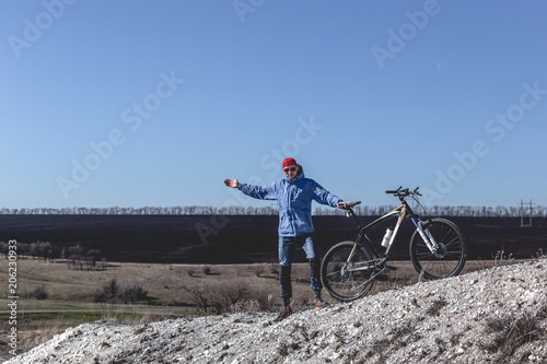Young guy with a bicycle on a chalky mountain