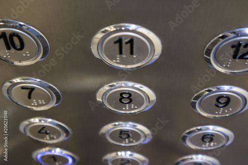 several stainless steel elevator panel push buttons, metal buttons in the Elevator, selective focus