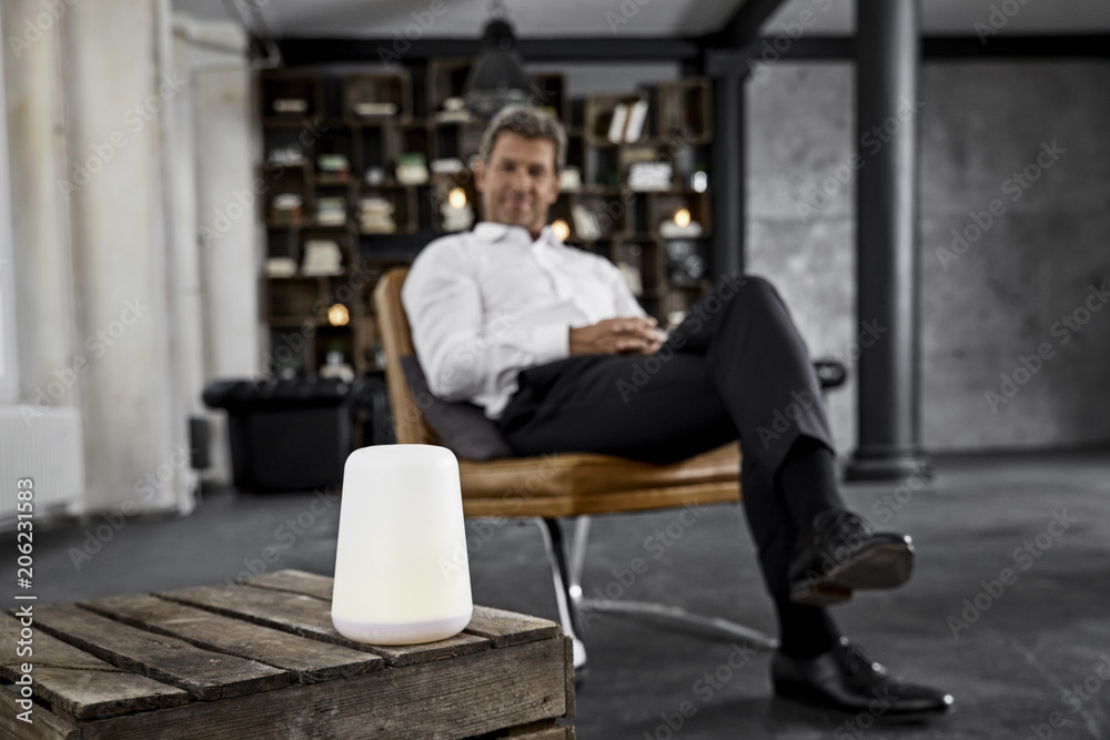 Mature man using voice-controlled digital assistant in loft Mature man using voice-controlled digital assistant in loft