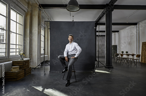 Portrait of mature businessman in front of black backdrop 