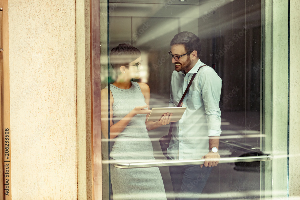 Picture of young businesspeople talking in elevator