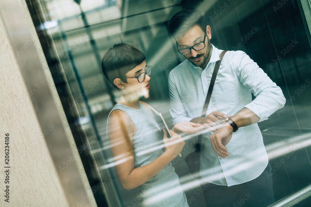 Picture of young businesspeople talking in elevator Picture of young businesspeople talking in elevator