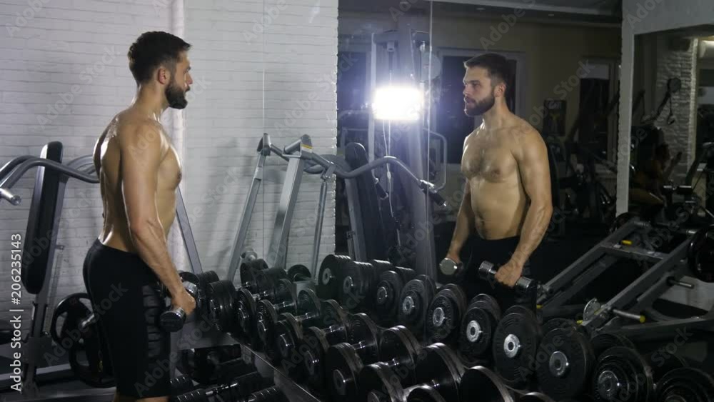 Video Stock A man of a sporty physique trains the muscles of both hands