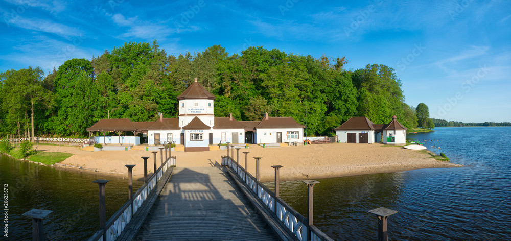 Panorama of the  city beach at the olecko lake great.  Historic the hill and wooden pier built from around 1930.