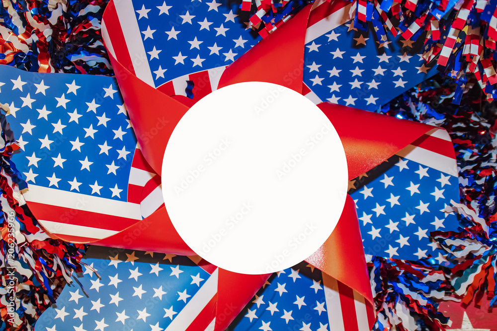 Obraz premium red whte and blue pinwheel with stars and strips surrounded by tinsel with white circle for copy in center