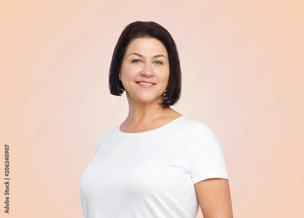 body positive and people concept - happy middle age woman in white t-shirt over beige background body positive and people concept - happy middle age woman in white t-shirt over beige background