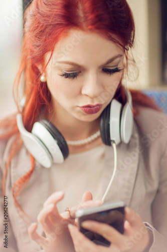young beautiful woman listening to music in a train, subway, urban mood concept