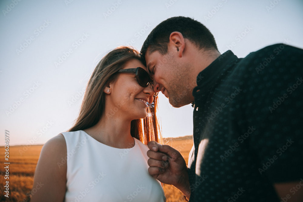 A couple of lovers looking at each other and fooling around.Guy gives flower to girl.Summer day.Couple in love A couple of lovers looking at each other and fooling around.Guy gives flower to girl.Summer day.Couple in love