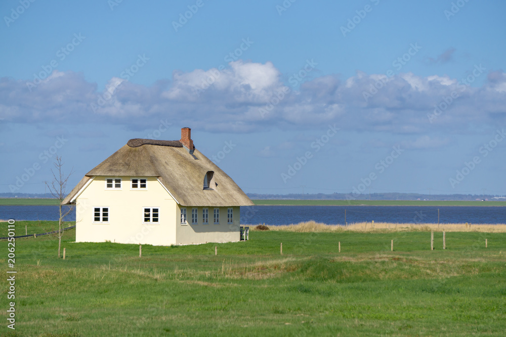 House with thatched roof on the Danish island Römö with a view of the Wadden Sea House with thatched roof on the Danish island Römö with a view of the Wadden Sea