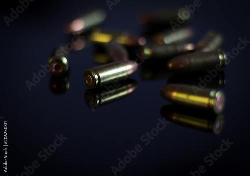 Bullets in shadow on a glass table.9 mm bullet