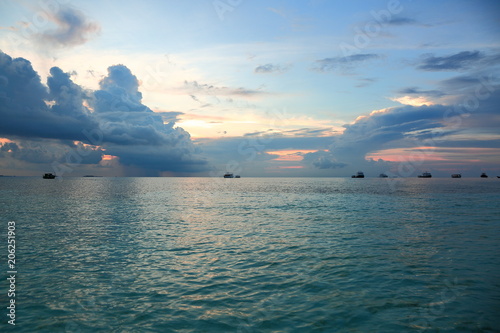 Gorgeous view of sunset on Indian Ocean, Maldives. Blue water and blue sky with white clouds. Amazing nature backgrounds.