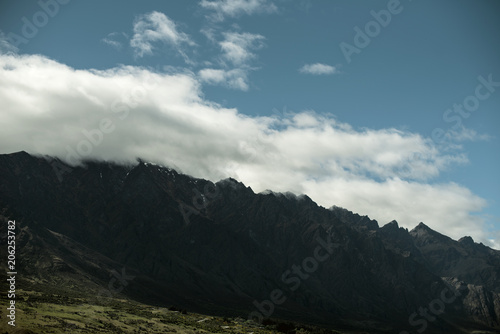 Fototapeta Naklejka Na Ścianę i Meble -  Landscape of shady mountains with huge clouds over them. day shot with blue sky.