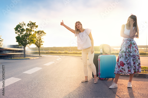 Photography Two pretty girls hitchhiking on roadside