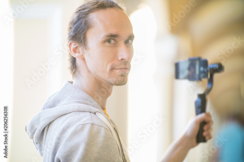Photography the guy shoots himself on an electronic stabilizer for video shooting