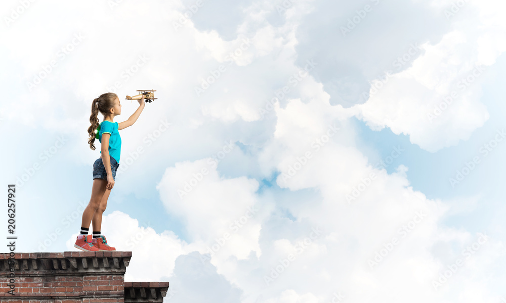 Concept of careless happy childhood with girl dreaming to become pilot Concept of careless happy childhood with girl dreaming to become pilot