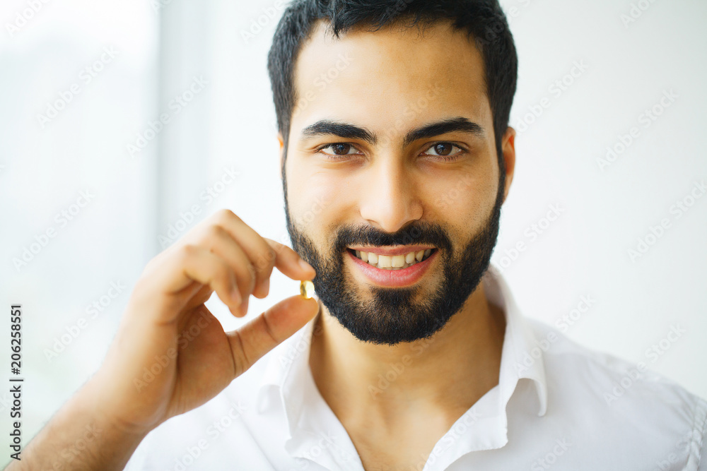 Obraz premium Beautiful Man Taking Pill, Medicine. Vitamins And Supplements