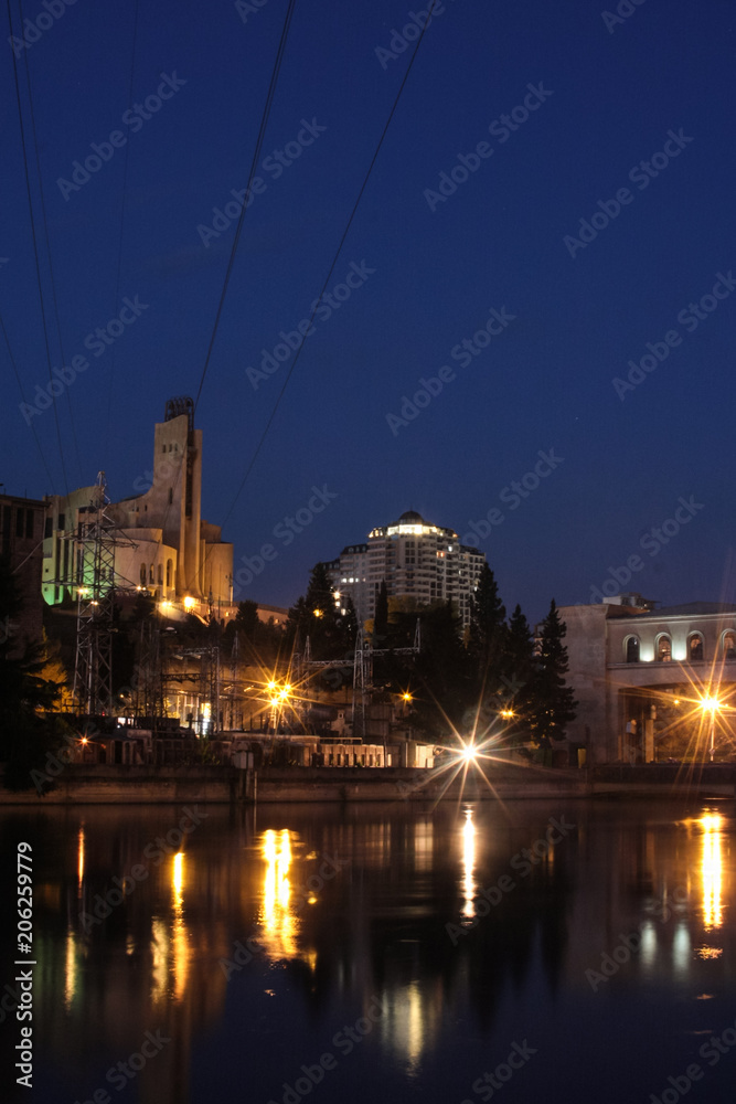 soviet palace and damb in tbilisi at night with reflection