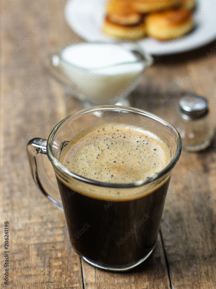 black coffee with foam in a transparent glass cup (portion of hot coffee) black coffee with foam in a transparent glass cup (portion of hot coffee)