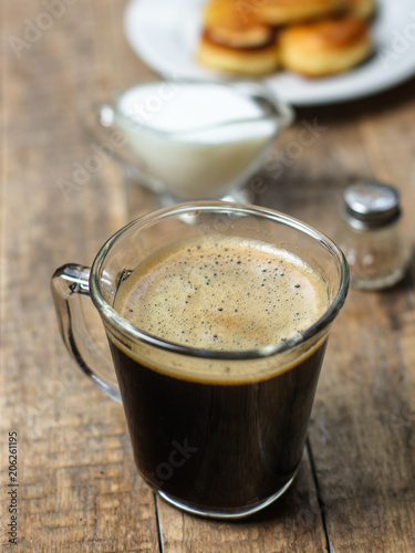 black coffee with foam in a transparent glass cup (portion of hot coffee)