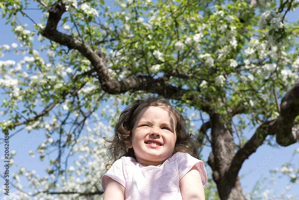 Little girl staying under blossom tree in spring Little girl staying under blossom tree in spring