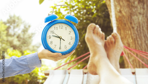 summer time and vacation, clock with feet in the hammock resting
