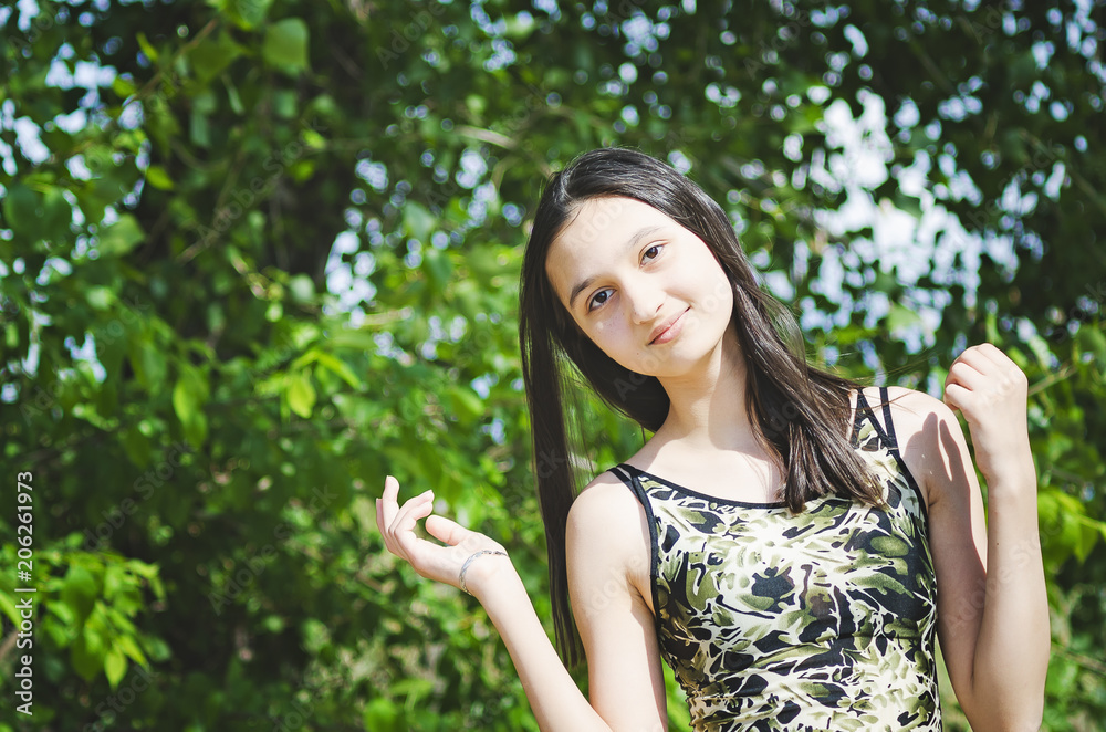 Pretty teen girl brunette with long hair on a background of summer nature. Pretty teen girl brunette with long hair on a background of summer nature.