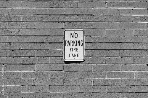 No Parking Fire Lane sign on cinder block wall