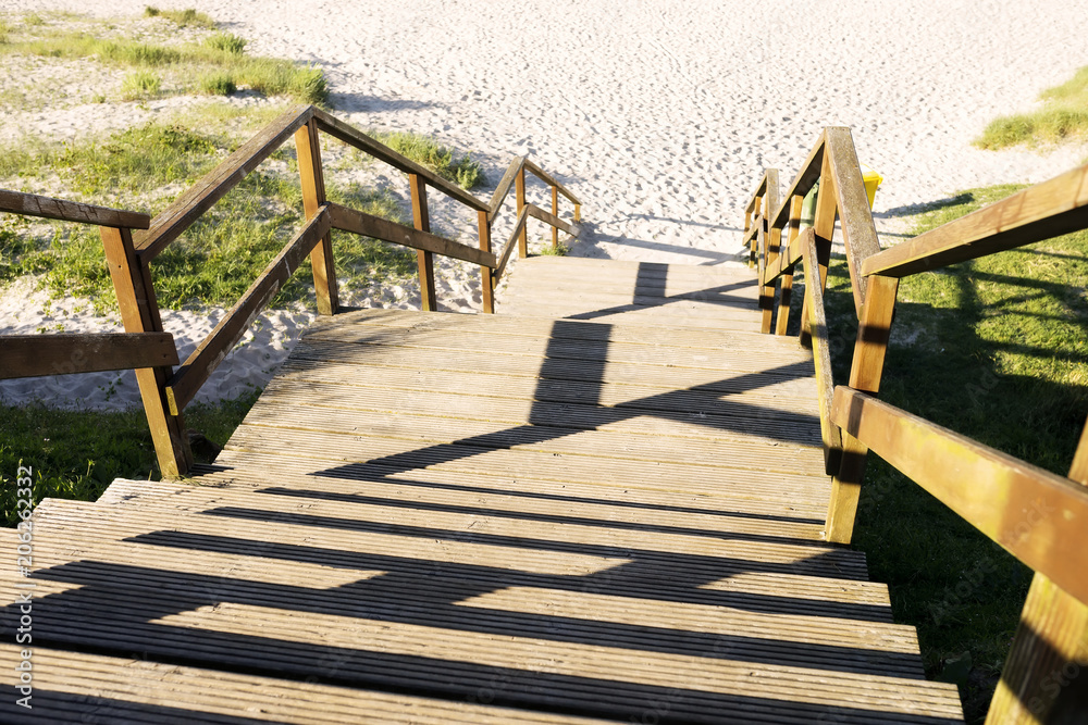 path to beach with wooden staircase path to beach with wooden staircase