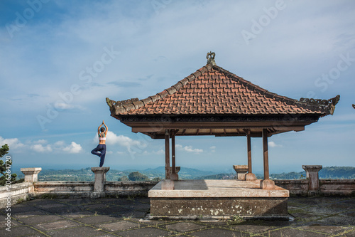woman practicing yoga in the traditional balinesse gazebo © Kate