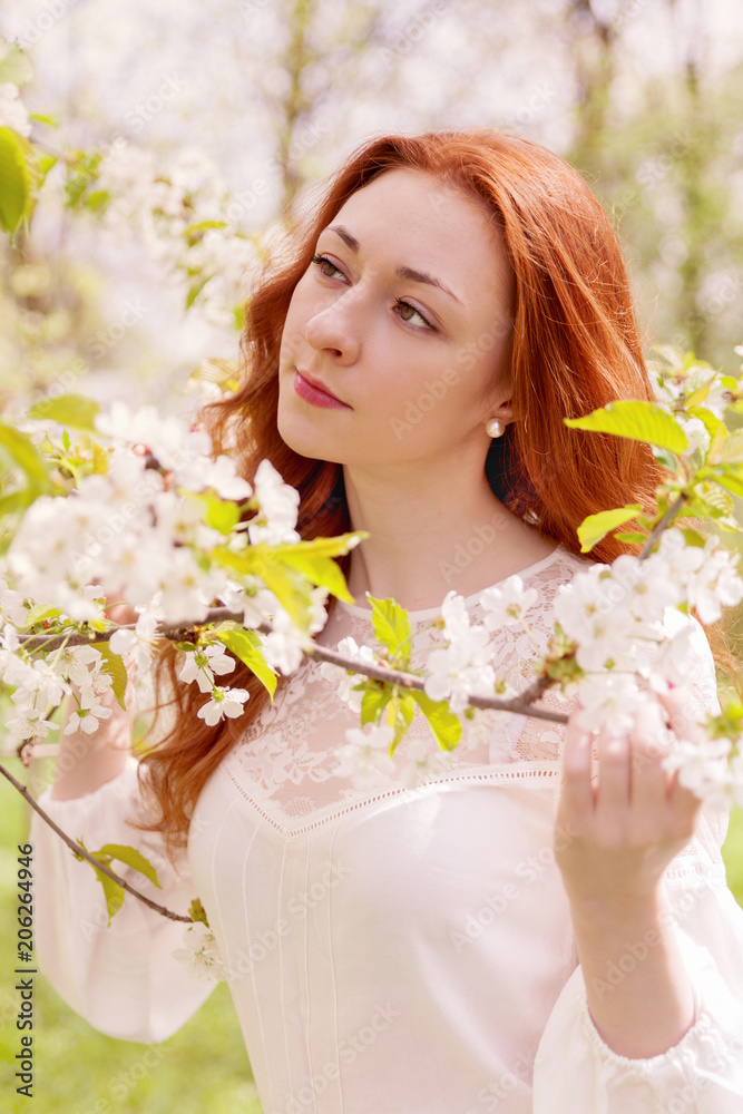 Young ginger hair woman near white tender blossoming tree. fairy dreamlike mood of the spring and summer. Beautiful romantic lady smiling bride, wedding. Copy space background. Young ginger hair woman near white tender blossoming tree. fairy dreamlike mood of the spring and summer. Beautiful romantic lady smiling bride, wedding. Copy space background.