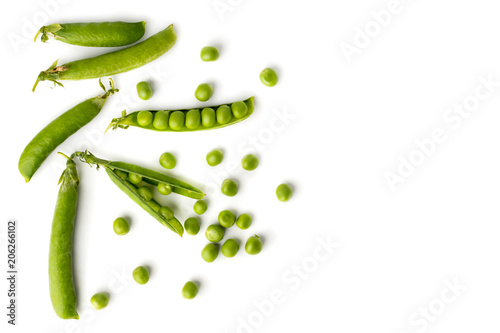 Green peas in pods and scattered on a white Fototapet