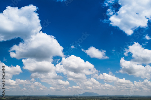 Blue sky background with clouds and landscape view on bottom