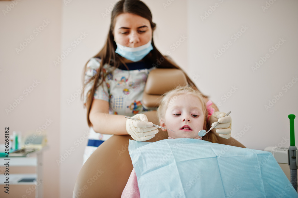 Little baby girl at dentist chair. Children dental.