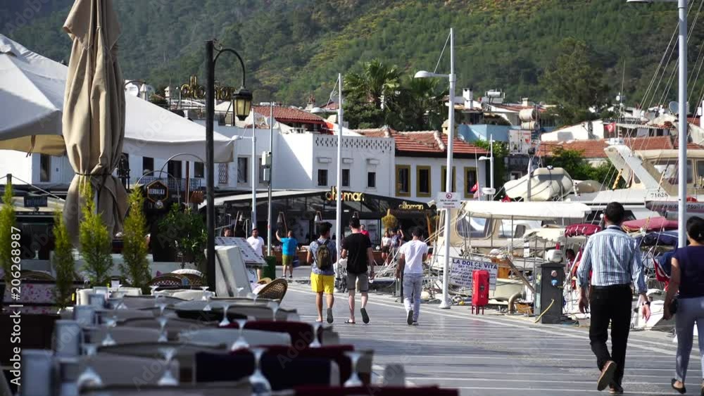 People walking and cycling along waterfront at old town in Marmaris. Turkey. 4K.