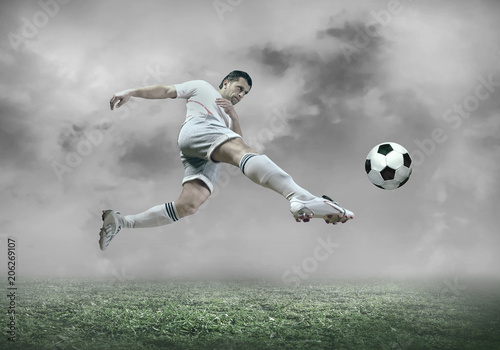 Football player with ball in action under sky with clouds