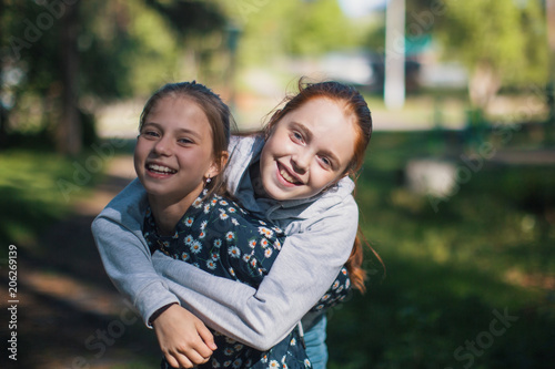 Two girls sisters or girlfriends having fun outdoors. Portraits. © De Visu
