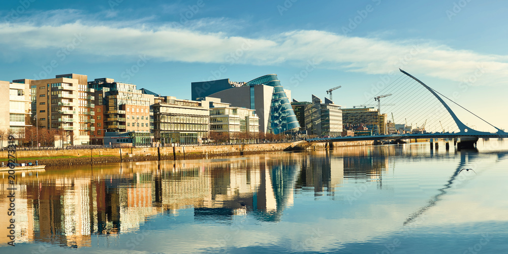 Fototapeta premium Nowoczesne budynki i biura nad rzeką Liffey w Dublinie w jasny, słoneczny dzień
