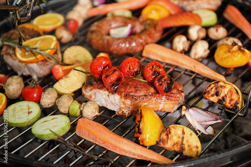 Barbecue grill with delicious cooked meat and vegetables, closeup