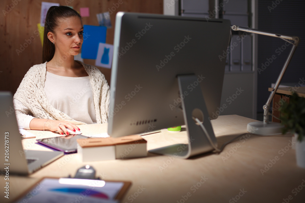 Young woman working in office, sitting at desk. Young woman. Young woman working in office, sitting at desk. Young woman.