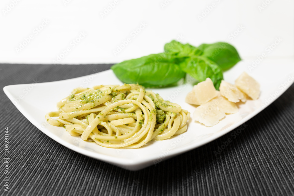 Linguine (or Trenette) with Genovese pesto sauce, a typical sauce of the Liguria region (Italy). The basil is the fundamental ingredient of this delicious sauce together with Parmesan cheese.