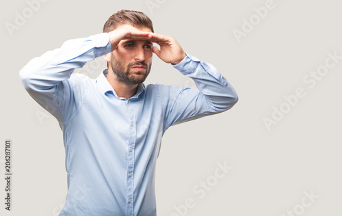 young handsome man looking far wearing blue t shirt,  . person isolated against monochrome background