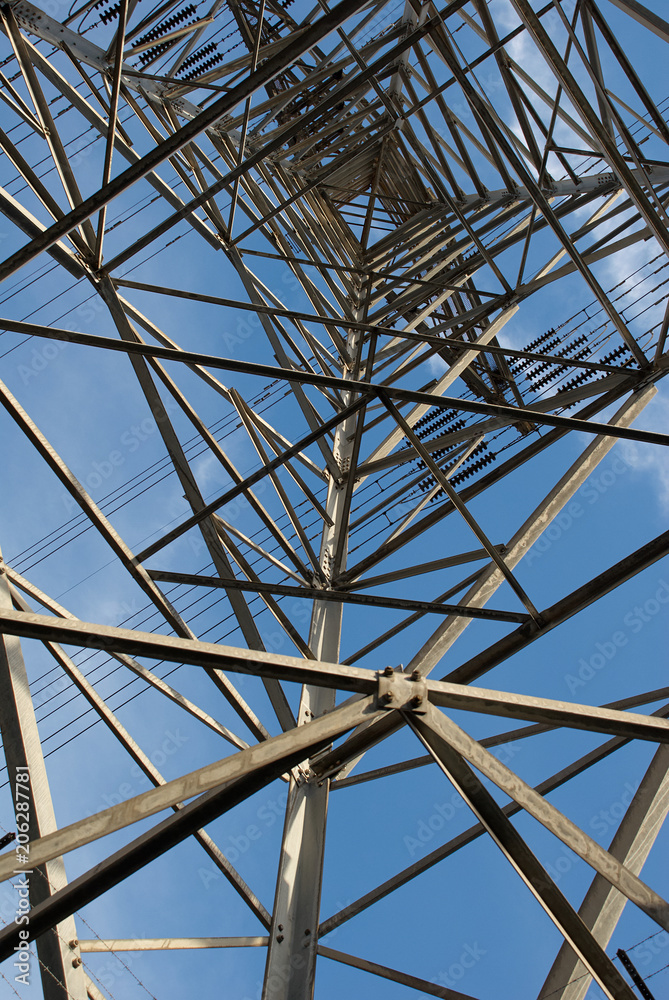 Electric power pylon shapes close up against a blue sky Electric power pylon shapes close up against a blue sky
