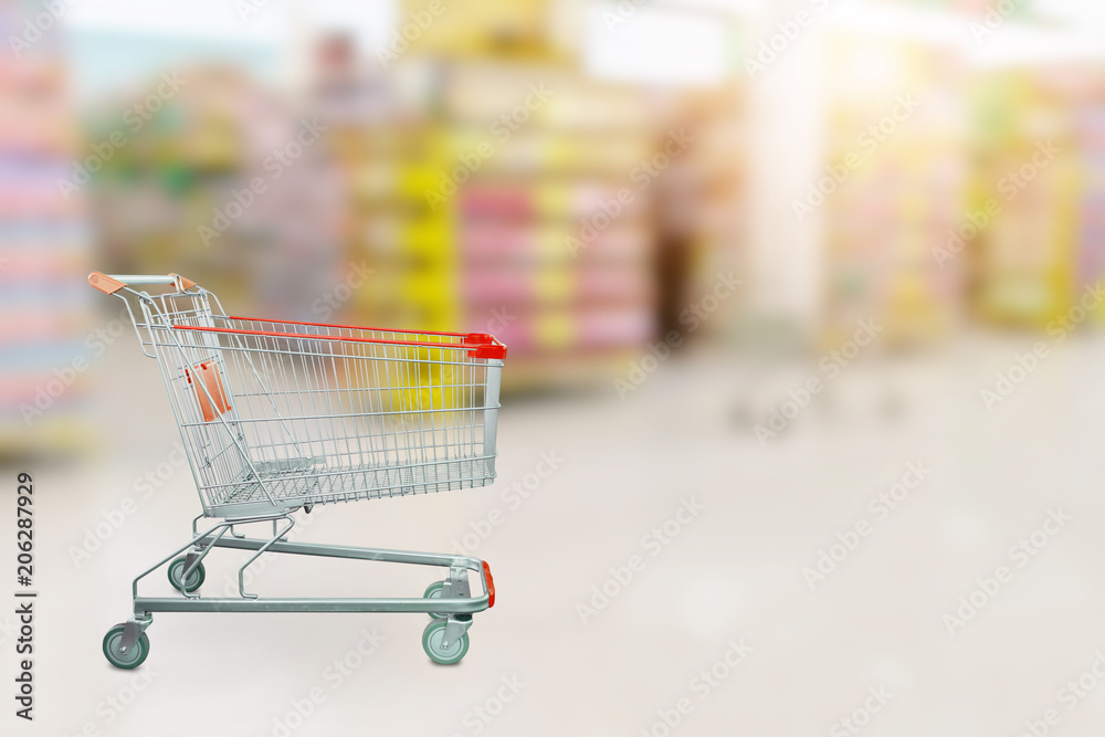 Empty red shopping cart with Abstract blur supermarket discount store product shelves interior defocused background