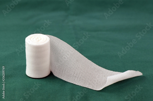 Fototapet Sterile roll gauze on green operation cloth.