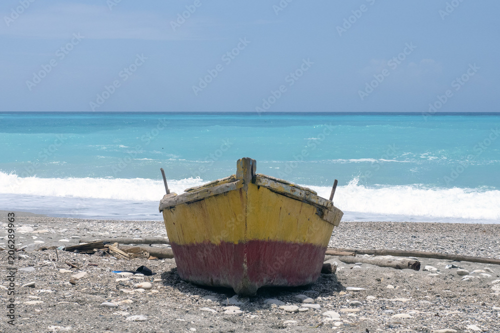 Red and yellow boat on the beach against the sea Red and yellow boat on the beach against the sea